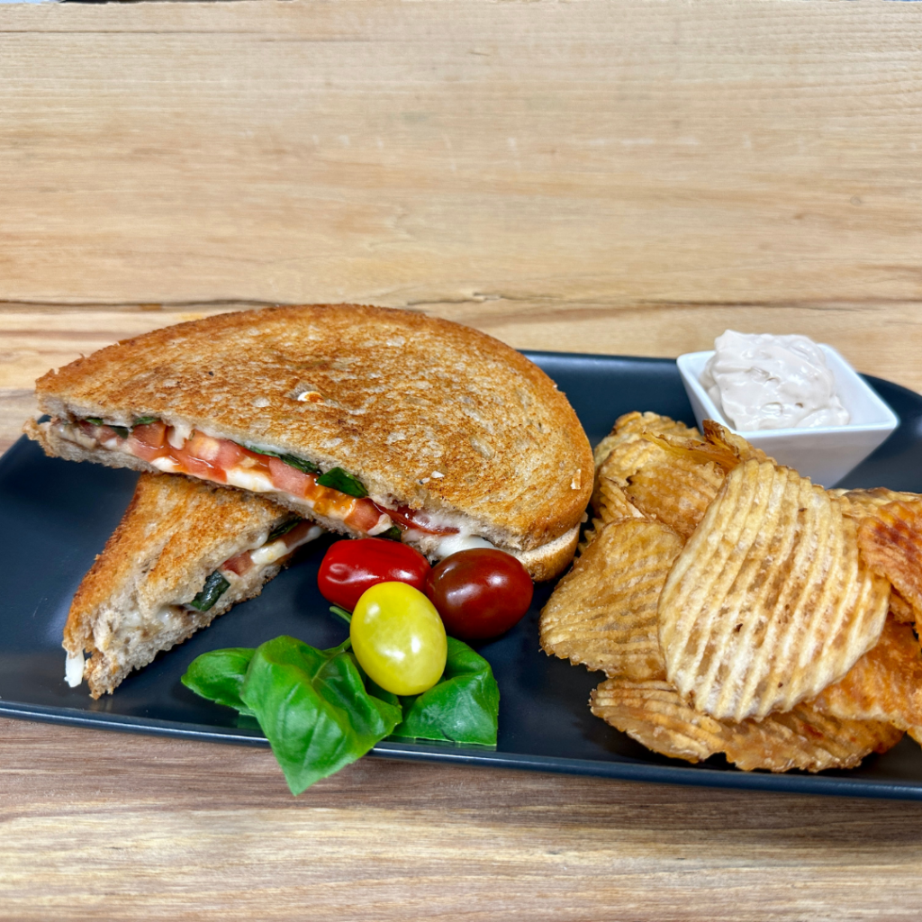 Caprese grilled cheese served with chips and dip.