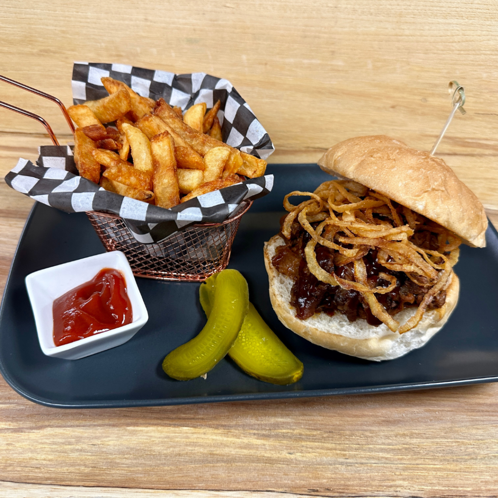smoked brisket sandwich served with French fries.
